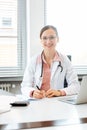 Beautiful doctor with computer in her surgery or office Royalty Free Stock Photo