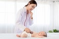 Beautiful doctor hand using stethoscope examining adorable infant heart, asian newborn baby get sick sleep during examine by