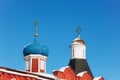 Beautiful domes with golden crosses over the fortress walls in Russia against the blue clear sky