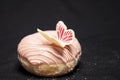 Beautiful donut covered with pink chocolate and decorated with a beautiful butterfly, side view