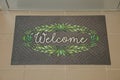 Beautiful doormat with word Welcome on floor near entrance, above view