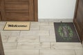 Beautiful doormats with word Welcome on floor near doors in hall Royalty Free Stock Photo