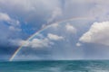 Beautiful double rainbow over ocean water with storm clouds in the sky closeup.