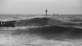 Beautiful dramatic black and white stormy landscape image of waves crashing onto beach at sunrise Royalty Free Stock Photo