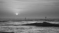 Beautiful dramatic black and white stormy landscape image of waves crashing onto beach at sunrise Royalty Free Stock Photo