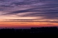 Beautiful dramatic evening sunset background. Orange, blue, purple sky with clouds and black silhouettes of urban buildings Royalty Free Stock Photo