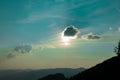 Beautiful dramatic mountain silhouette landscape scenic view evening blue sky background with sun light rays behind cloud Royalty Free Stock Photo