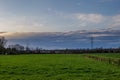 Beautiful dramatic orange and blue cloud and sky after storm over agricultural field. Royalty Free Stock Photo