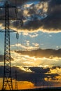 Beautiful dramatic sky and clouds, sunset lights over the transmission tower electricity pylon on a field Royalty Free Stock Photo