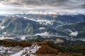 Beautiful dramatic snowy Caucasus mountain peaks winter scenery with ski lifts, slopes and a village in the river valley Royalty Free Stock Photo