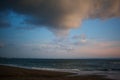 Beautiful dramatic sunrise with cloudy dark sky and green ocean waves. Moody seascape. Natural background of seaside and Royalty Free Stock Photo