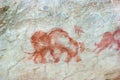 Beautiful drawings of ancient people in red ocher on the walls of a limestone cave Royalty Free Stock Photo