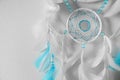 Beautiful dream catcher hanging on white wall, closeup