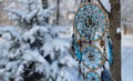 Beautiful dream catcher with owl against conifer in snow and with copy space.