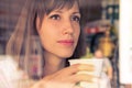 Beautiful dreaming young girl with cup of coffee