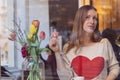 Beautiful dreaming young woman sitting in coffee shop near the window,drining coffee and eating dessert