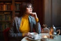 Beautiful dreamy girl in stylish sharp glasses. With a cup in his hands. Royalty Free Stock Photo