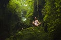 Beautiful dreamy portrait of young attractive Asian woman enjoying nature sitting lotus pose doing yoga meditating relaxed at Royalty Free Stock Photo