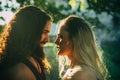 Beautiful dreamy woman looking in her boyfriends eyes. Couple in sunshine. Sensual couple in love walking in the park