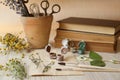 Beautiful dried flowers, books, brushes and paints on wooden table