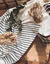 Beautiful dried hydrangea, eucalyptus, scissors and linen fabric on rustic wooden chair, rural still life flat lay. Phone photo Royalty Free Stock Photo