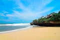 Beautiful drini beach in yogyakarta with bright blue sky, white sand and high cliffs.