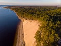 Beautiful drone areal photography view of large dune and pine forest near river Lielupe. Photo taken on sunset