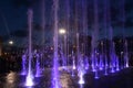 Beautiful dry fountain with bright illuminated tall jets Royalty Free Stock Photo