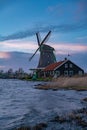 Beautiful Dutch landscape of Zaanse Schans village. Ancient windmills at the water\'s edge against a blue sky at dusk Royalty Free Stock Photo