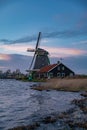 Beautiful Dutch landscape of Zaanse Schans village. Ancient windmills at the water\'s edge against a blue sky at dusk Royalty Free Stock Photo