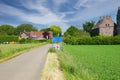 Beautiful dutch rural landscape, cycle path road, green meadow, village entrance sign, medieval castle - Ohe en Laak, Netherlands