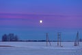 A beautiful early dawn landscape with a moon rising above the trees.