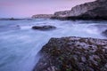 A beautiful early evening seascape with dramatic rocks and misty waves