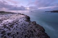 A beautiful early morning seascape with rocks and misty waves in the foreground