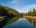 Beautiful early morning view of a creek with reflections of blue sky, mountains and trees on water Royalty Free Stock Photo