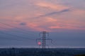 Beautiful early morning view of power lines with electricity transmission pylon and epic purple sunrise over Irish Sea, Dublin Royalty Free Stock Photo