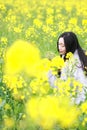 At beautiful early spring, a young woman stand in the middle of yellow flowers filed which is the biggest in Shanghai Royalty Free Stock Photo