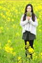 At beautiful early spring, a young woman stand in the middle of yellow flowers filed which is the biggest in Shanghai Royalty Free Stock Photo