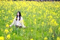At beautiful early spring, a young woman stand in the middle of yellow flowers filed which is the biggest in Shanghai Royalty Free Stock Photo