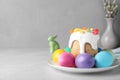 Beautiful Easter cake and painted eggs on light grey marble table. Space for text Royalty Free Stock Photo