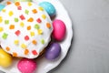 Beautiful Easter cake and painted eggs on light grey table, top view Royalty Free Stock Photo