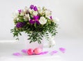 A beautiful Easter composition with a bouquet of flowers, pink painted chicken eggs and feathers on a white background Royalty Free Stock Photo