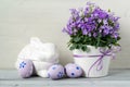 Beautiful easter decoration with Campanula flowers, Easter eggs and ceramic rabbit, on white wooden background Royalty Free Stock Photo