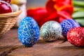 Easter eggs with tulips on weathered wooden background