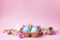 Traditional easter card template with pastel colors painted organic eggs in wicker basket with hay and decorative wildflowers. Royalty Free Stock Photo