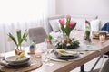 Beautiful Easter table setting with beautiful flowers in living room Royalty Free Stock Photo