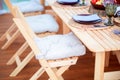 Beautiful eco-friendly wooden furniture on the summer terrace of the restaurant. Folding chairs for camping