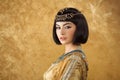 Beautiful Egyptian woman like Cleopatra on golden background