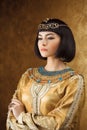 Beautiful Egyptian woman like Cleopatra on golden background