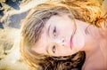 Beautiful eight year old girl laying on the beach